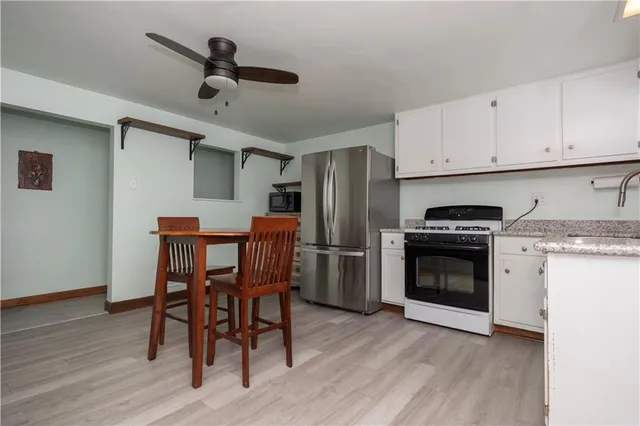 a kitchen with stainless steel appliances kitchen island hardwood floor sink and stove