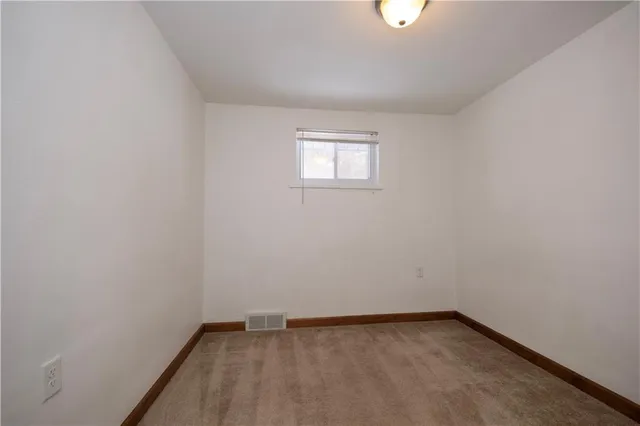 a view of a small space with wooden floor and a window