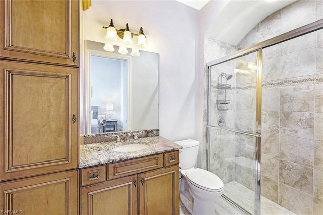 a bathroom with a granite countertop sink toilet and shower