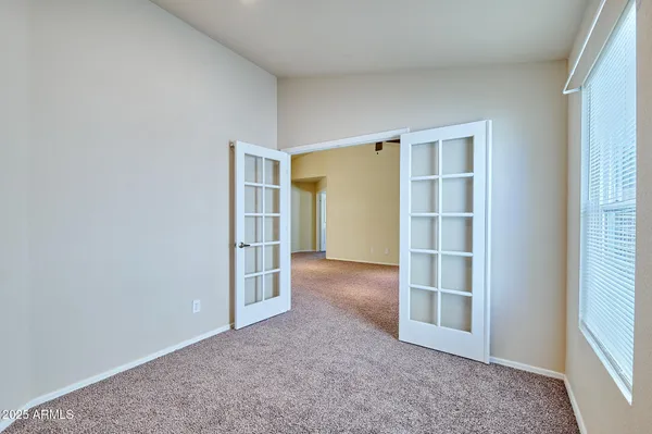 an empty room with closet and windows
