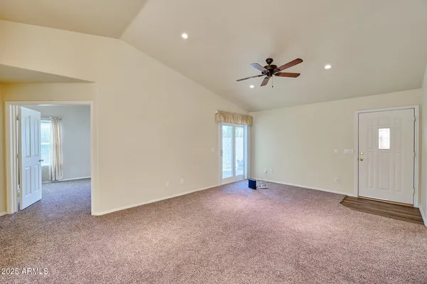 an empty room with fan and windows