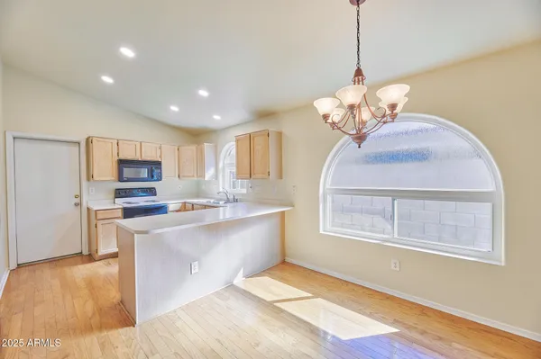 a view of a kitchen with microwave and windows