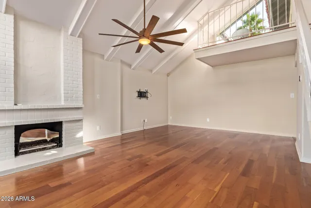 a view of a livingroom with wooden floor and a ceiling fan