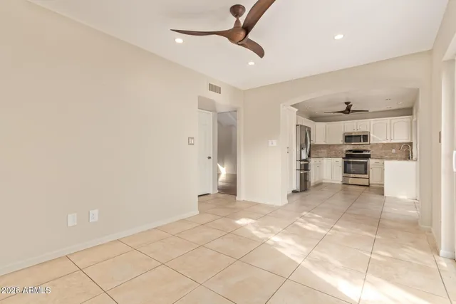 a view of a kitchen with refrigerator and wooden floor