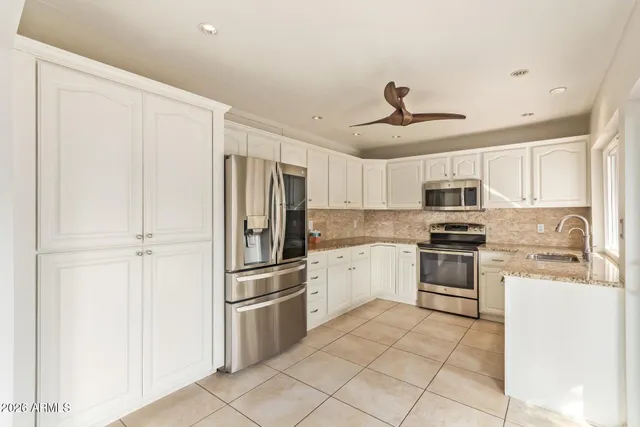 a kitchen with stainless steel appliances a refrigerator sink and stove