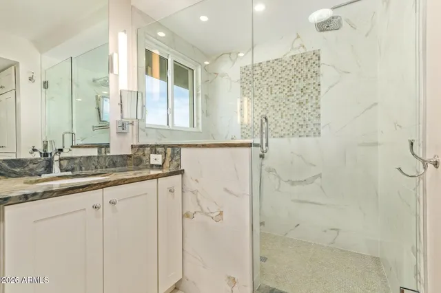 a bathroom with a granite countertop shower sink and mirror