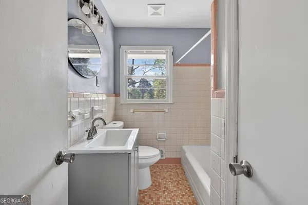 a bathroom with a sink a toilet and a mirror