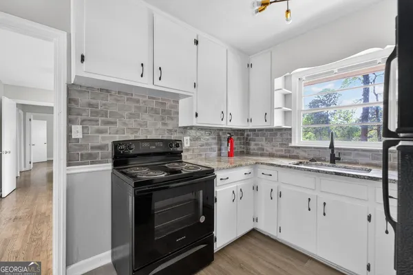 a kitchen with cabinets appliances a sink and a window