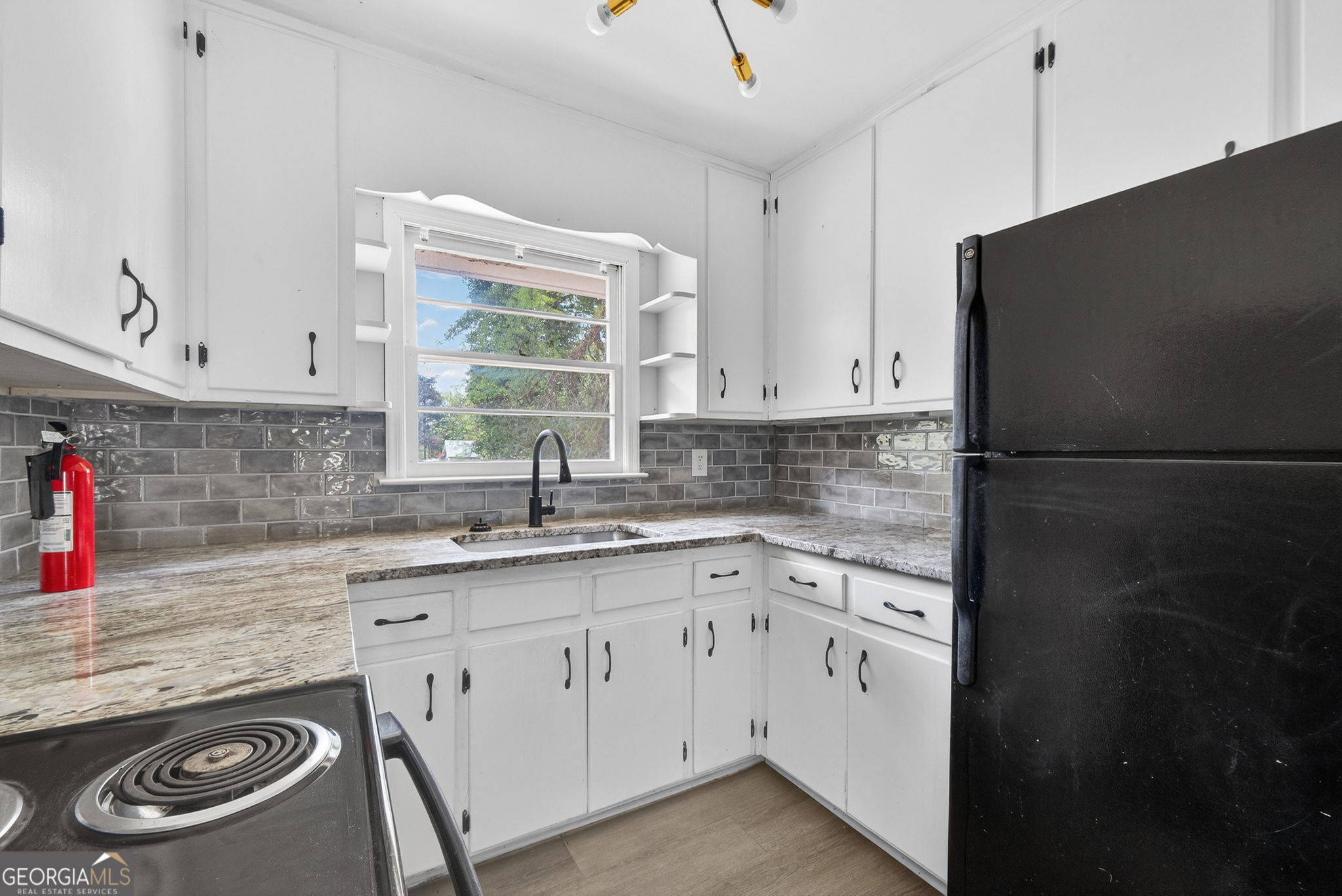 3825 Highway 81 Hampton, GA 30228 - Photo 5 of 25 a kitchen with a sink stove and cabinets