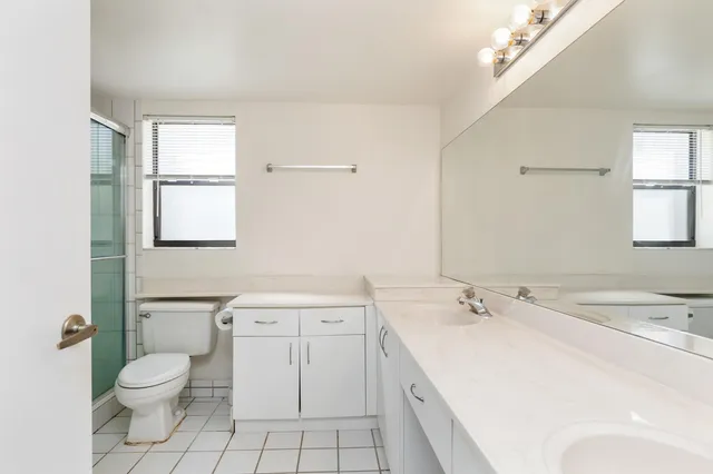 a spacious bathroom with a toilet sink and mirror