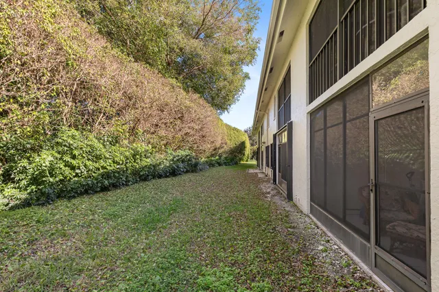 a view of a yard with plants and brick wall