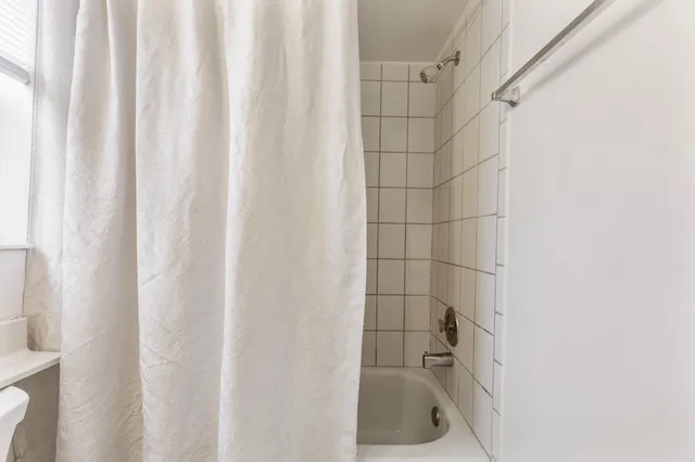 a bathroom with a shower curtain and sink