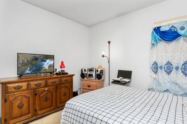 a bedroom with a bed and dresser with mirror