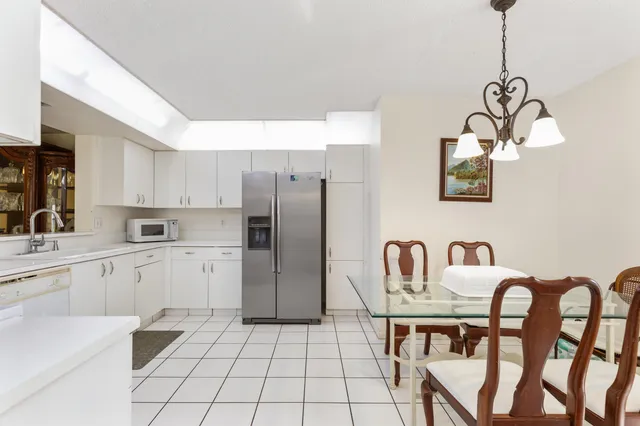 a kitchen with stainless steel appliances granite countertop a kitchen island a white cabinets a sink and a refrigerator