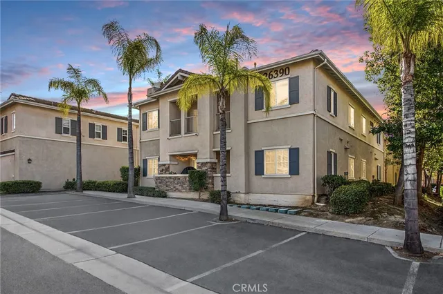 a view of a hallway with wooden floor and a bathroom