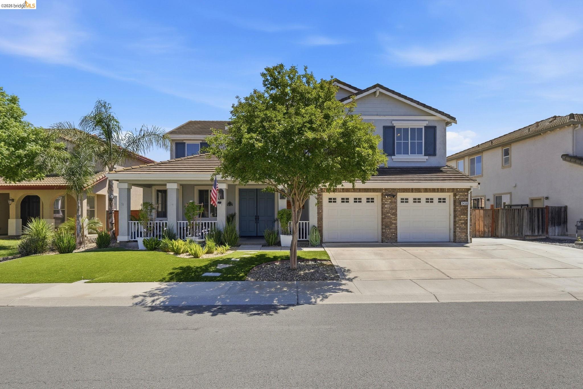 a front view of a house with a yard and potted plants