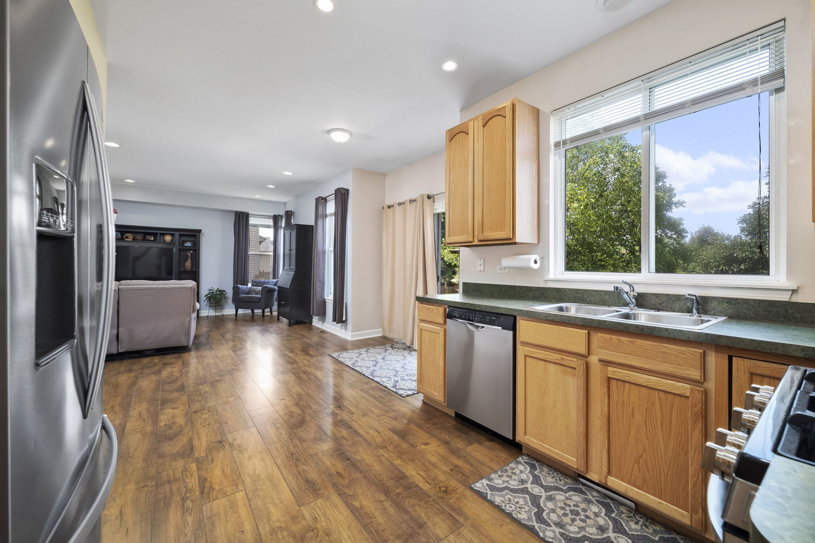 3815 Cherry Tree Lane Joliet, IL 60435 - Photo 10 of 37 a large kitchen with stainless steel appliances granite countertop a refrigerator a sink dishwasher a stove and a dining table with wooden floor