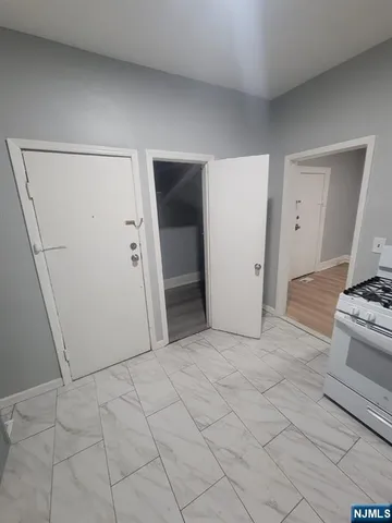a view of kitchen with refrigerator and white cabinets