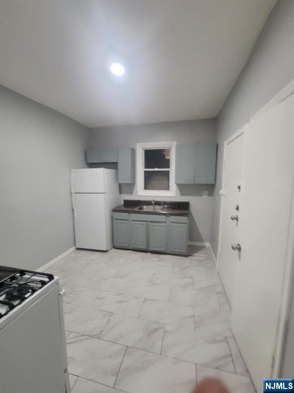 2 Montrose Terrace, Unit 1M Irvington, NJ 07111 - Photo 4 of 13 a view of kitchen with refrigerator and white cabinets