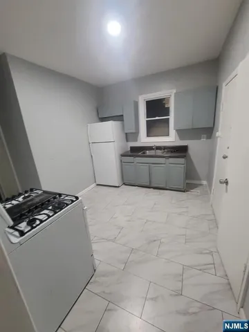 a large kitchen with a stove and a refrigerator