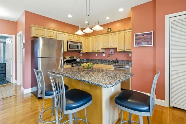a kitchen with stainless steel appliances granite countertop sink stove and refrigerator