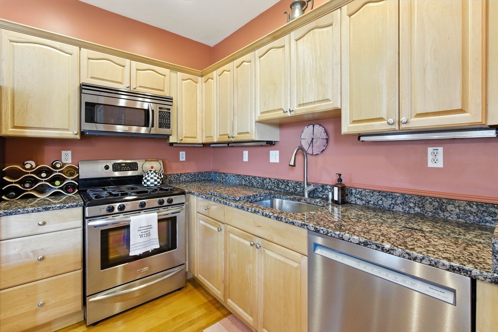 131 Derby Street, Unit 3F Salem, MA 01970 - Photo 12 of 37 a kitchen with stainless steel appliances granite countertop a stove a sink and a microwave
