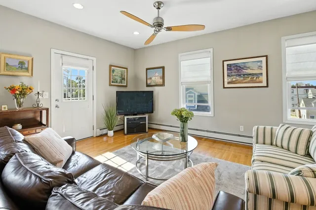 a living room with furniture a flat screen tv and a window