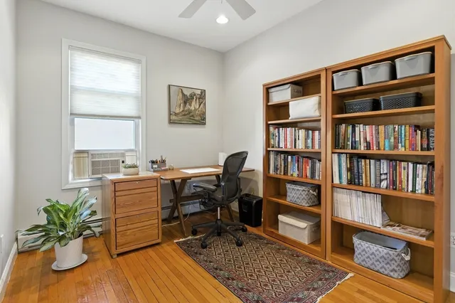 a view of a workspace with furniture and a book shelf