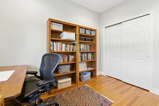 a view of a workspace with furniture and a bookshelf