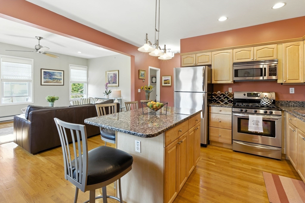 131 Derby Street, Unit 3F Salem, MA 01970 - Photo 8 of 37 a kitchen with stainless steel appliances granite countertop a stove a refrigerator a kitchen island a dining table and chairs