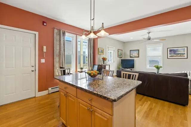 a kitchen with granite countertop a stove a sink and a wooden cabinets