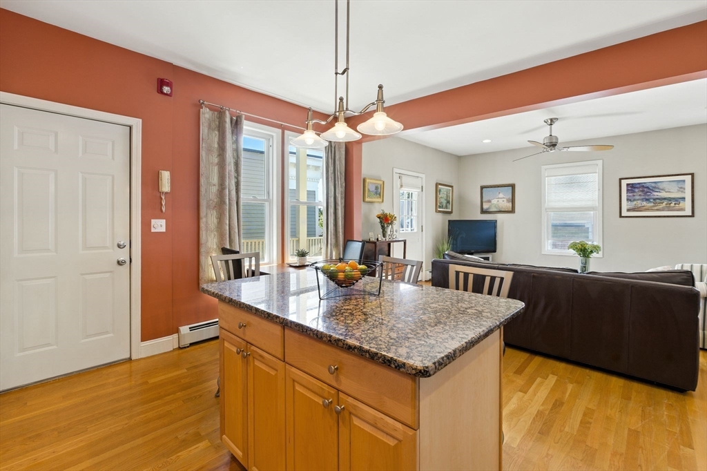 131 Derby Street, Unit 3F Salem, MA 01970 - Photo 9 of 37 a kitchen with granite countertop a stove a sink and a wooden cabinets