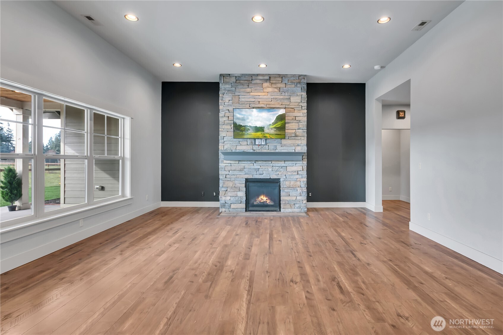 8106 Spurgeon Creek Road Southeast Olympia, WA 98513 - Photo 8 of 29 a view of empty room with wooden floor and fireplace