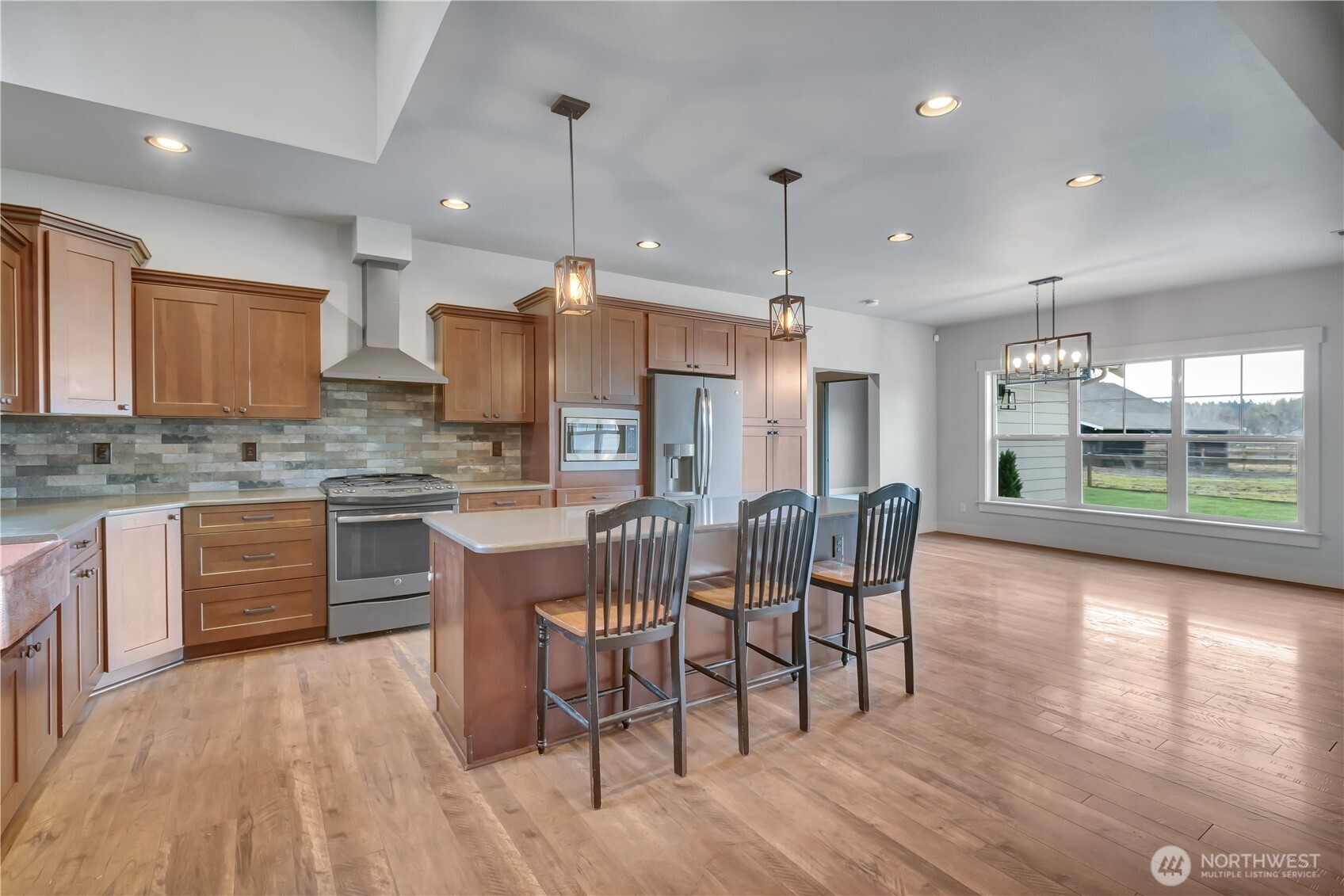 8106 Spurgeon Creek Road Southeast Olympia, WA 98513 - Photo 9 of 29 a kitchen with stainless steel appliances granite countertop a stove top oven a sink dishwasher a dining table and chairs with wooden floor