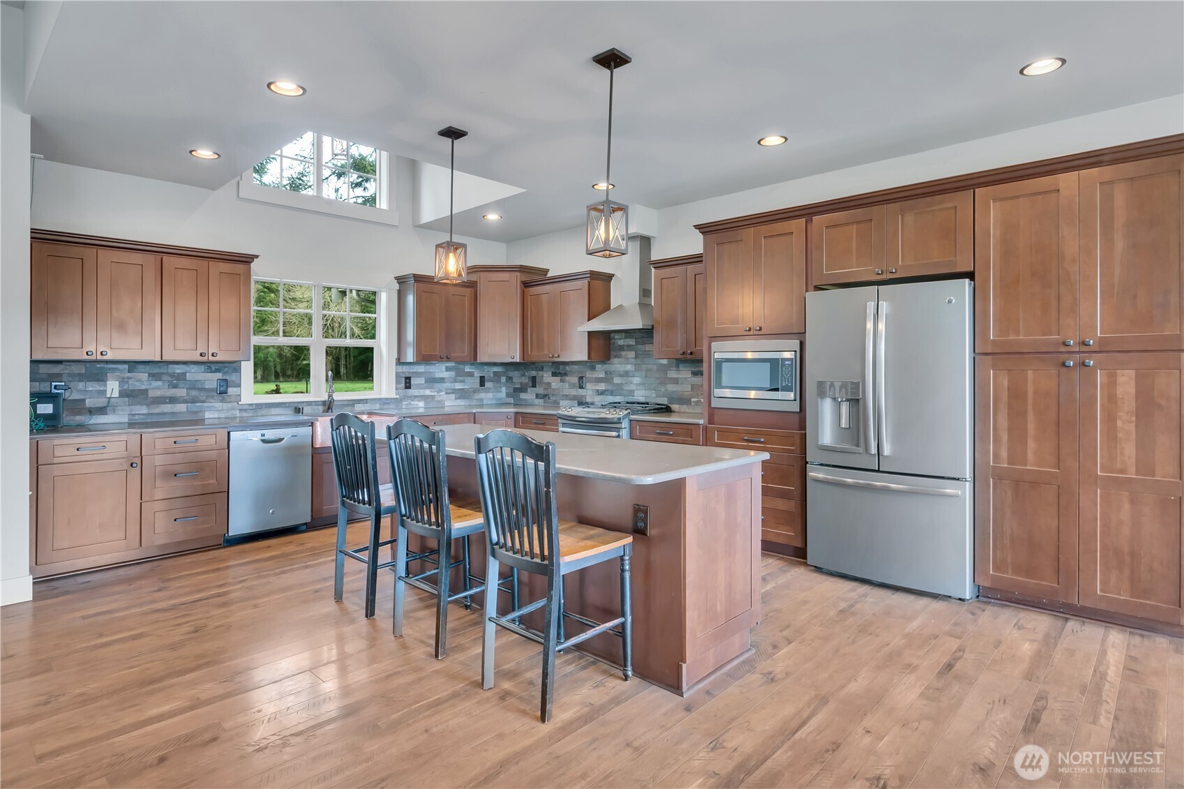 8106 Spurgeon Creek Road Southeast Olympia, WA 98513 - Photo 10 of 29 a kitchen with kitchen island granite countertop wooden floors appliances and cabinets