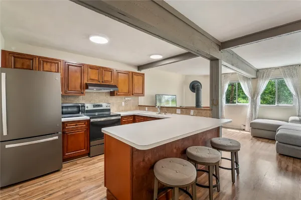 a large kitchen with a table chairs refrigerator and window