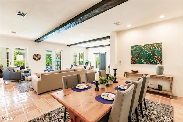 a living room with furniture a large window and a dining table