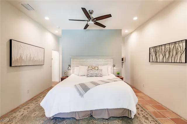 a bedroom with a bed and painting on the wall