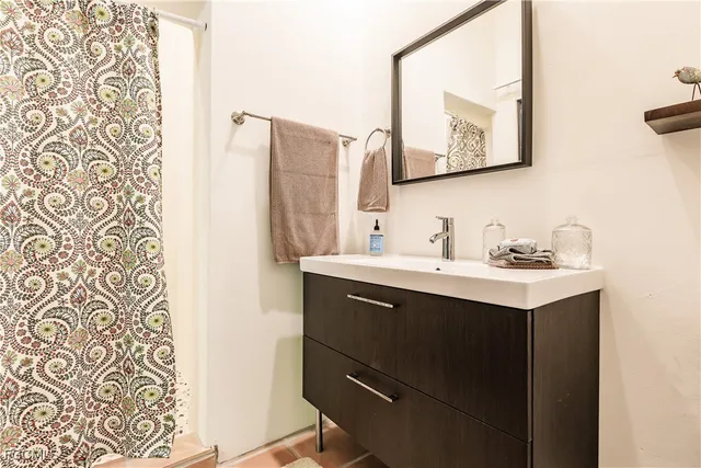 a bedroom with a bed a chair and potted plant