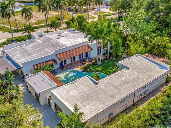 an aerial view of a house with a yard and large trees