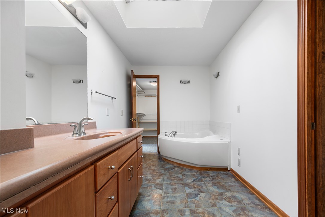 2317 Raintree Street Northeast Canton, OH 44705 - Photo 18 of 40 Bathroom with vanity, a bath, and a skylight