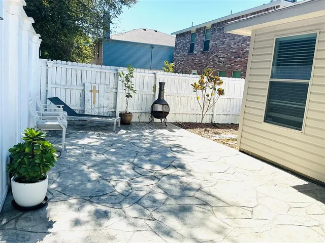 a view of a patio with table and chairs potted plants
