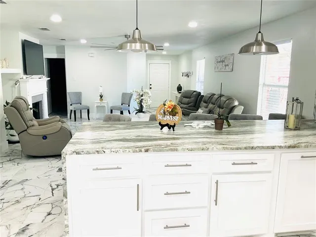 a kitchen with kitchen island granite countertop a sink and cabinets