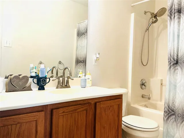 a bathroom with a granite countertop sink a toilet and shower