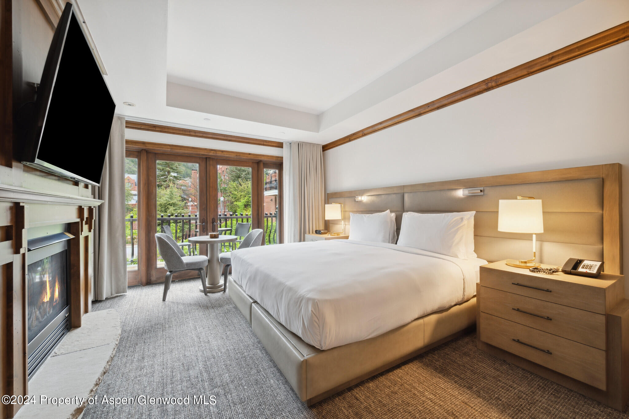 415 East Dean St Unit 22 Week 6 Aspen, CO 81611 - Photo 12 of 25 a bedroom with a large bed and a flat tv screen