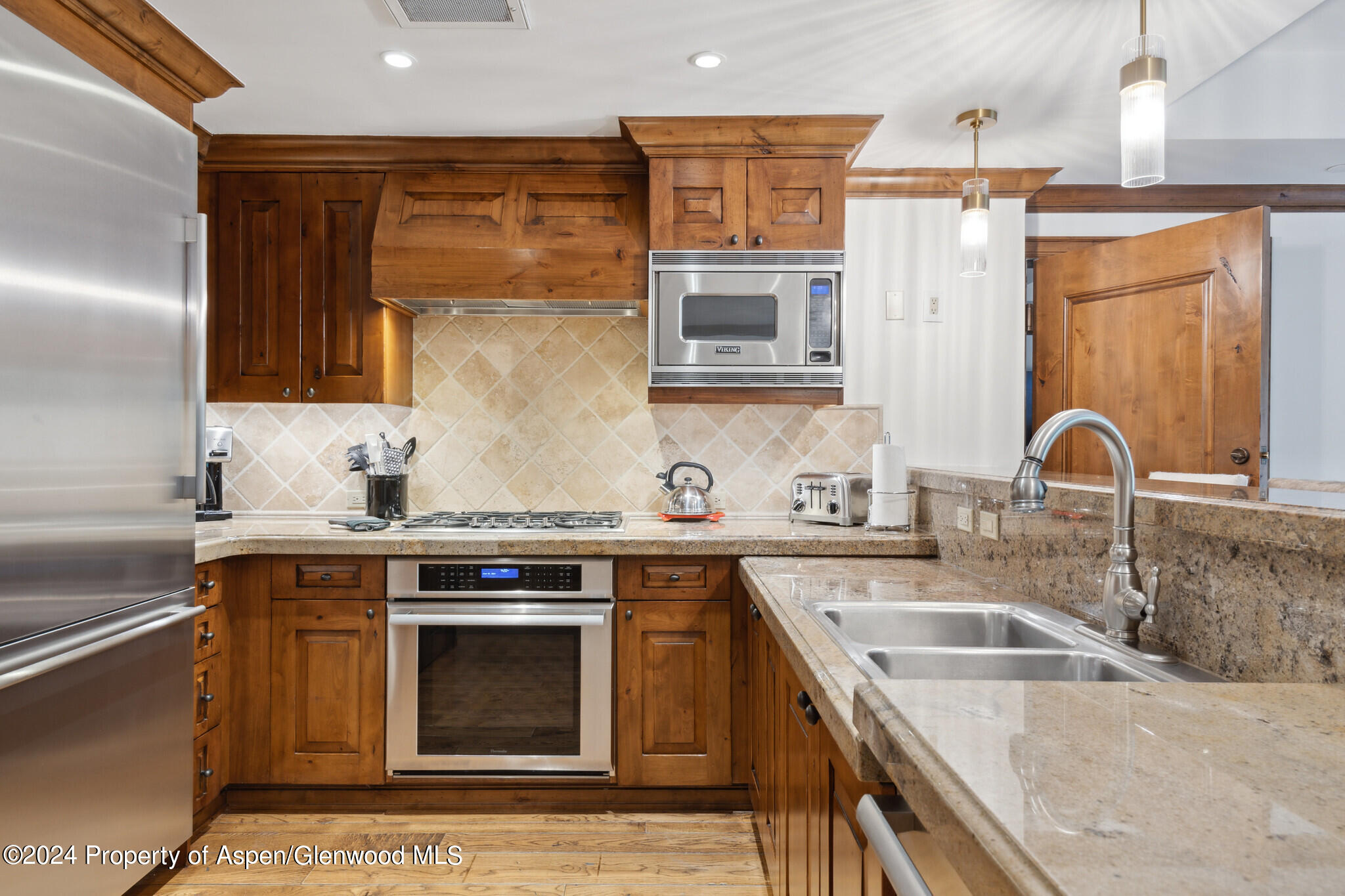 415 East Dean St Unit 22 Week 6 Aspen, CO 81611 - Photo 8 of 25 a kitchen with stainless steel appliances granite countertop a sink stove and refrigerator