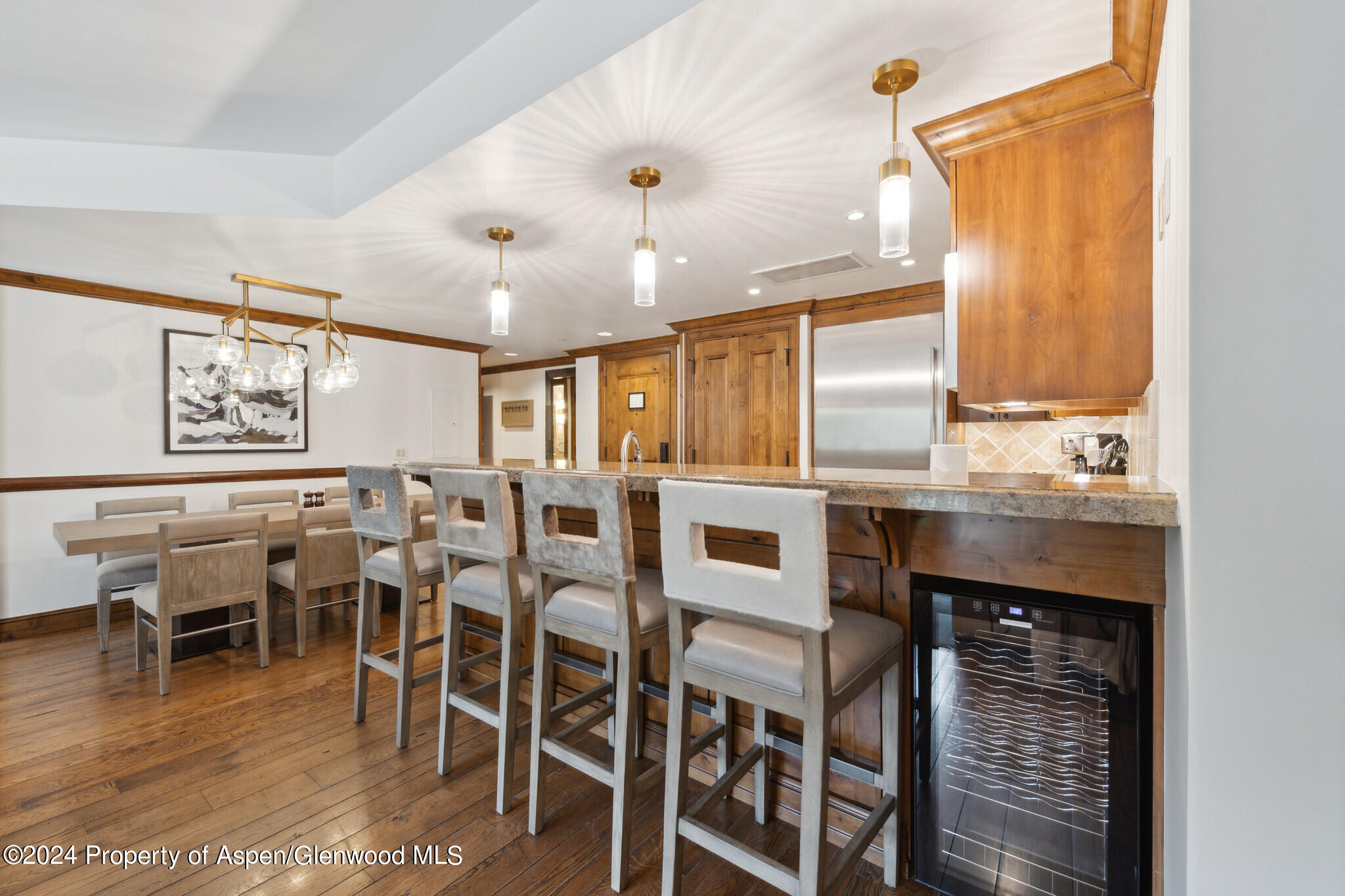415 East Dean St Unit 22 Week 6 Aspen, CO 81611 - Photo 9 of 25 a kitchen with stainless steel appliances kitchen island granite countertop a table chairs sink and cabinets