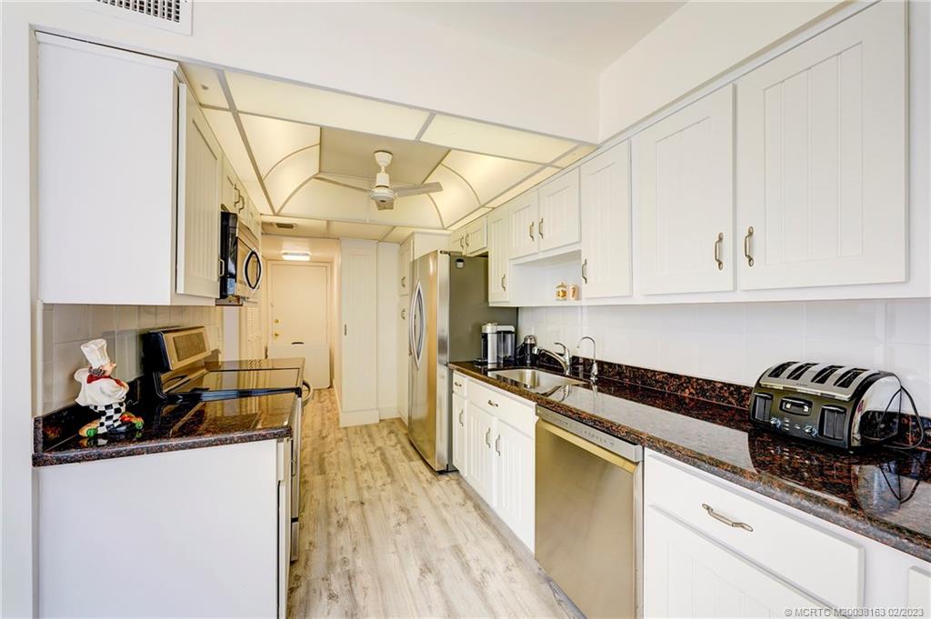 1180 South Ocean Boulevard, Unit 8B Boca Raton, FL 33432 - Photo 31 of 62 a kitchen with granite countertop a sink a stove and refrigerator