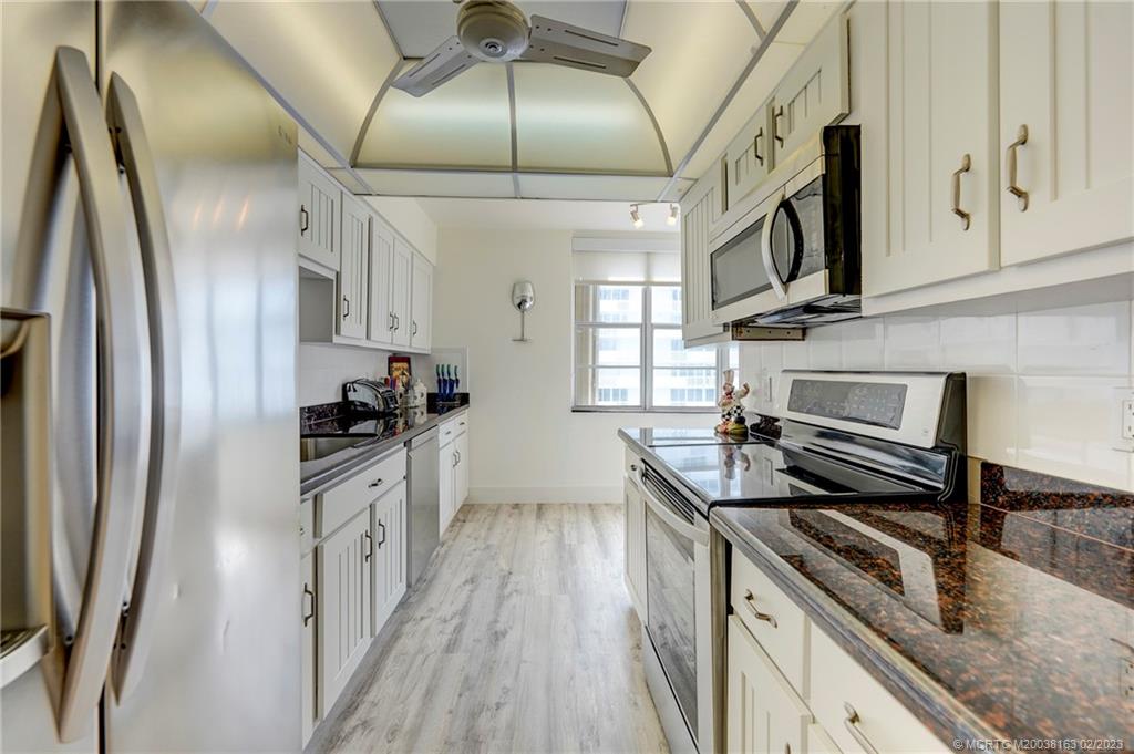 1180 South Ocean Boulevard, Unit 8B Boca Raton, FL 33432 - Photo 34 of 62 a kitchen with stainless steel appliances granite countertop a sink and a refrigerator