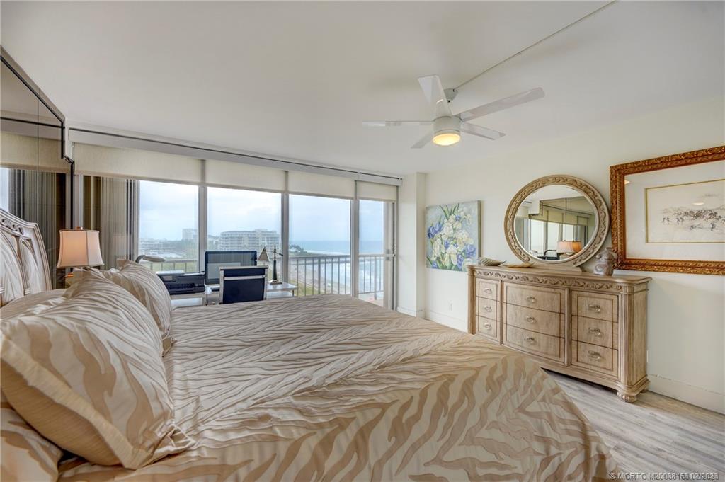 1180 South Ocean Boulevard, Unit 8B Boca Raton, FL 33432 - Photo 54 of 62 a bedroom with a bed a mirror on dresser and a large window